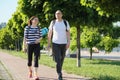 Talking middle-aged man and woman, couple walking along park road Royalty Free Stock Photo