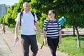 Talking middle-aged man and woman, couple walking along park road Royalty Free Stock Photo