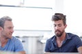 Talking over the details. two male colleagues discussing work in the office. Royalty Free Stock Photo