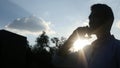 Talking on Phone, in front of Sun during Sunset, Silhouette Royalty Free Stock Photo