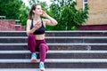 Talking on phone after training. Smiling girl sitting on stairs outdoor Royalty Free Stock Photo