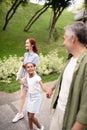 Beautiful adopted girl talking to daddy while walking with parents