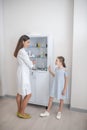 Little patient talking to the doctor near the vitrine with medicines Royalty Free Stock Photo