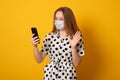 Talking on video call young girl using her smartphone disposable face mask, to prevent others from corona COVID-19 Royalty Free Stock Photo