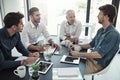 When he talks, everyone listens. a group of businessmen having a meeting around a table in an office. Royalty Free Stock Photo