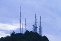 The tall antenna with the mountain and the sky.