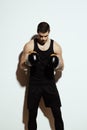Tall attractive sportsman posing in boxing gloves over white background