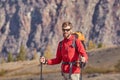 Tall backpacker with poles in hand.