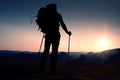 Tall backpacker with poles in hand. Sunny hike day in rocky mountains. Hiker with big backpack stand on rocky view point above mis Royalty Free Stock Photo