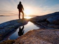 Tall backpacker watch clear sunny daybreak over sea. Hiker Hiker enjoy breathtaking sunrise Royalty Free Stock Photo