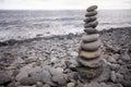 Tall balanced pile of pebble stones on a stony beach Royalty Free Stock Photo