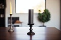 a tall, black candle holder with an unlit pillar candle Royalty Free Stock Photo
