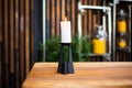 a tall, black candle holder with an unlit pillar candle