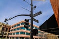 A tall black pole with street signs that read `Atlanta` and `Roswell` and traffic signals surrounded by office buildings