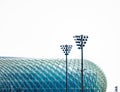 Tall blue Esplanade - Theatres on the Bay stands beside street lights and a fence in Singapore