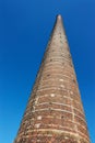 Tall brick chimney against blue sky background