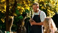 A tall broad shoulder sexy waiter is writing down the order from a table with two very beautiful white women and a black Royalty Free Stock Photo