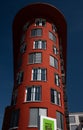 A tall brown-red house in the shape of a tower stands in Augsburg. The building is a dormitory with many small apartments. In the Royalty Free Stock Photo