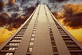 A tall building that goes into sunset sky and rainy clouds the sky. Royalty Free Stock Photo