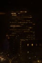 Tall building, skyscraper, at night, people at work at the office, overtime.Vertical shot Royalty Free Stock Photo