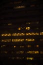 Tall building, skyscraper, at night, people at work at the office, overtime.Vertical shot Royalty Free Stock Photo