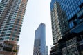 Tall building towering in center of city surrounded by large and small buildings.