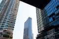 Tall building towering in center of city surrounded by large and small buildings.