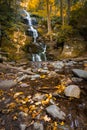 Tall cascading waterfall surrounded by dense foliage changing from summer to autumn. Buttermilk Falls, NJ Royalty Free Stock Photo