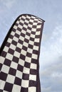 Tall checkered flag waving in the wind against the sky Royalty Free Stock Photo