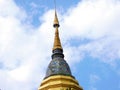 Tall chedi with a colorful mosaic and golden, multi-tiered parasol at the top