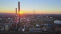 Tall chimneys of oil refinery with depot and huge storage tanks at sunset Royalty Free Stock Photo