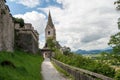 A tall church tower with a clock and an access path and wall defenses at the old Hochosterwitz Castle in Carinthia, Austria. Royalty Free Stock Photo