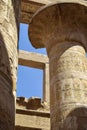 Tall columns of historical complex of Karnak temple with carved ancient Egyptian hieroglyphs and symbols. Royalty Free Stock Photo