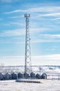 Tall Communications antenna overlooking grain silos on a rural property with the City of Calgary in the background in Rocky View Royalty Free Stock Photo