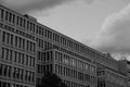 Brutalist architecture tall concrete building with many windows and gray sky and clouds in the background located in Prague