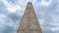 Tall concrete obelisk reaching into the cloudy sky Royalty Free Stock Photo