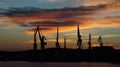 Tall cranes silhouettes at sunset, Pula, Croatia Royalty Free Stock Photo