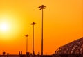 Tall electric pylon in the airport at sunset with an orange sky. Spotlights pole at the airfield. Energy support at the airport