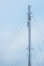 Tall frosty telecommunications tower against a partly cloudy sky