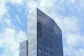 Tall glass beautiful elegant skyscraper under white clouds and blue sky on a spring day. Esentai Tower, Almaty, Kazakhstan Royalty Free Stock Photo