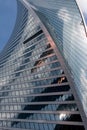 A tall glass business building with large windows.