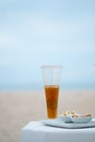 A tall glass of cold iced tea with sliced lemons on the beach with seascape background Royalty Free Stock Photo
