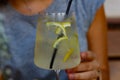 Tall glass of cold lemonade in woman`s hand on the table. Refreshment, drinks, beverag Royalty Free Stock Photo