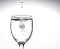 A tall glass, a glass of wine with clear water with bubbles floating in the mouth of the glass Inside