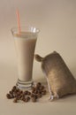 A tall glass of horchata next to a traditional sack of chufas Royalty Free Stock Photo