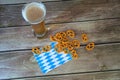 A tall glass of light beer on a traditional napkin and a group of salty pretzels Royalty Free Stock Photo