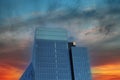 A tall glass modern office building with a blue sky and powerful red clouds at sunset in downtown Atlanta Royalty Free Stock Photo