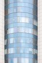 A tall glass office building with lots of teal windows and orange frames. Front view Royalty Free Stock Photo