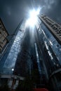 Tall glass skyscrapers reflect the setting sun, creating a stunning visual effect. Dark clouds loom overhead, adding Royalty Free Stock Photo