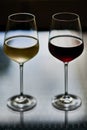 Tall glasses of red and yellow wine against black background. Royalty Free Stock Photo